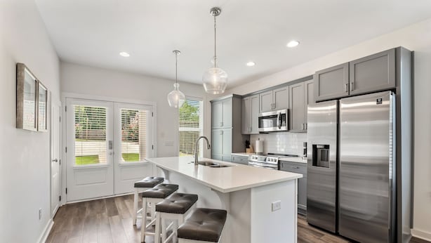 A modern kitchen with a large island, stainless steel appliances, and pendant lighting. - College & Mimosa House in Downtown Auburn, less than 1 mile to Toomer's (Auburn)