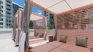 En tagterrasse med moderne design, med et siddeområde med hynder og et lille bord.