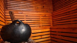 A black kettlebell on a wooden surface inside a room with wooden slats on the walls. - FINCA ENCANTO QUINDIO (Armenia)
