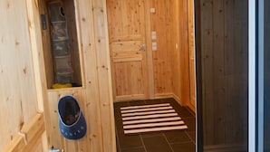 Interior de madera con una puerta, un zapatero y un felpudo a rayas.