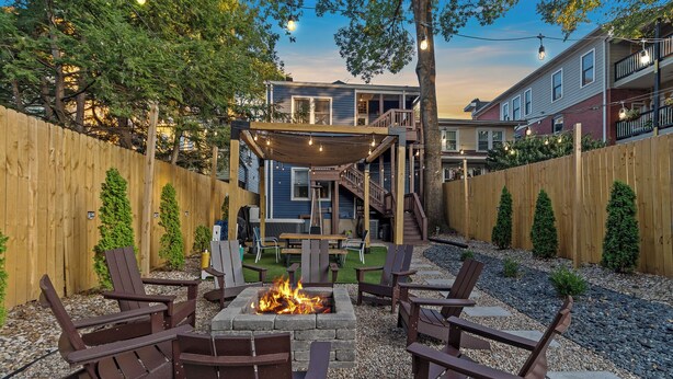 Un jardin avec un foyer, des sièges d’extérieur et un patio couvert.