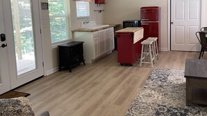 A spacious kitchen with a central island, a ceiling fan, and a refrigerator. - Private lake, cozy cottage near hiking, waterfalls, rafting, state parks, Helen (Demorest)