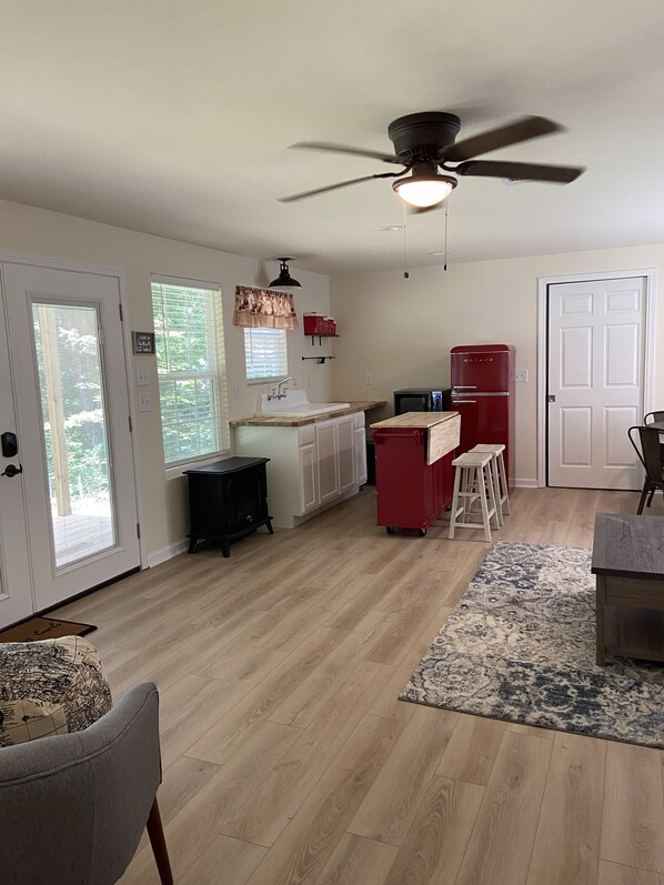 A spacious kitchen with a central island, a ceiling fan, and a refrigerator.