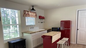 A compact kitchen with a sink, a microwave, a red refrigerator, a black stove, and a wooden countertop. - Private lake, cozy cottage near hiking, waterfalls, rafting, state parks, Helen (Demorest)