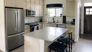 A modern kitchen with stainless steel appliances, a central island, and light wood cabinetry. - Modern Guest Suite, 3 Miles from Downtown Bozeman (Bozeman)