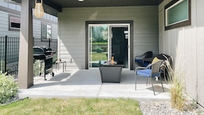 A covered patio area with a grill, outdoor seating, and a view of the backyard. - Modern Guest Suite, 3 Miles from Downtown Bozeman (Bozeman)