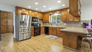 Una cucina moderna con mobili in legno, elettrodomestici in acciaio inossidabile e un'isola centrale.