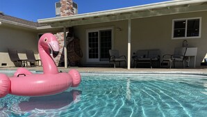 Una piscina trasparente con un gonfiabile a forma di fenicottero rosa.