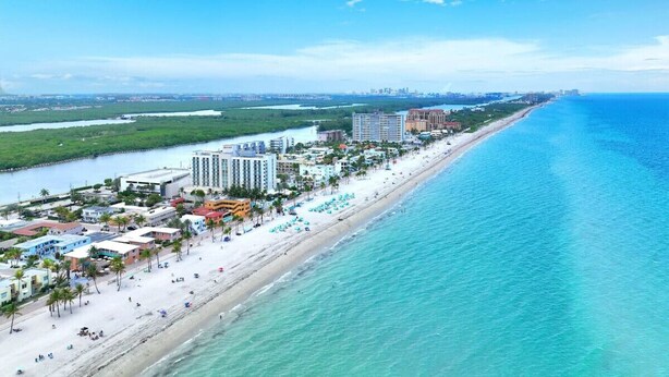 A coastal resort with a long beachfront, several high-rise hotels, and a sandy beach with umbrellas. - Spectacular Ocean View Corner Apartment! (Hollywood)