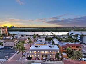 A coastal town with a mix of residential and commercial buildings, a clear sky, and a body of water in the background. - Amazing 1st Floor Apartment Just Steps to Beach (Hollywood)