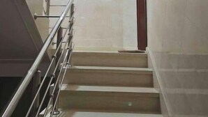 Una escalera con barandillas de metal y pared de azulejos.