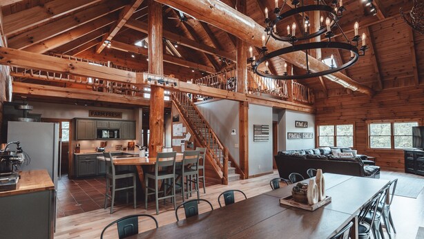 A spacious log cabin interior with a dining area, kitchen, and living room. - High Meadows Secluded Luxury Lodge, 20+ Acres, Hot Tub, Private Trails, Wifi (Rockbridge)