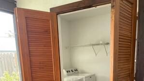 Ein Waschraum mit Waschmaschine und Trockner, einer Holztür und einem gemusterten Teppich.