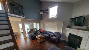 A spacious living room with a sectional sofa, a fireplace, and a television. - 10 Mile View on Lake Murray, SC, Putting Green, Hot Tub, Lake Edge Fire Pit (Gilbert)