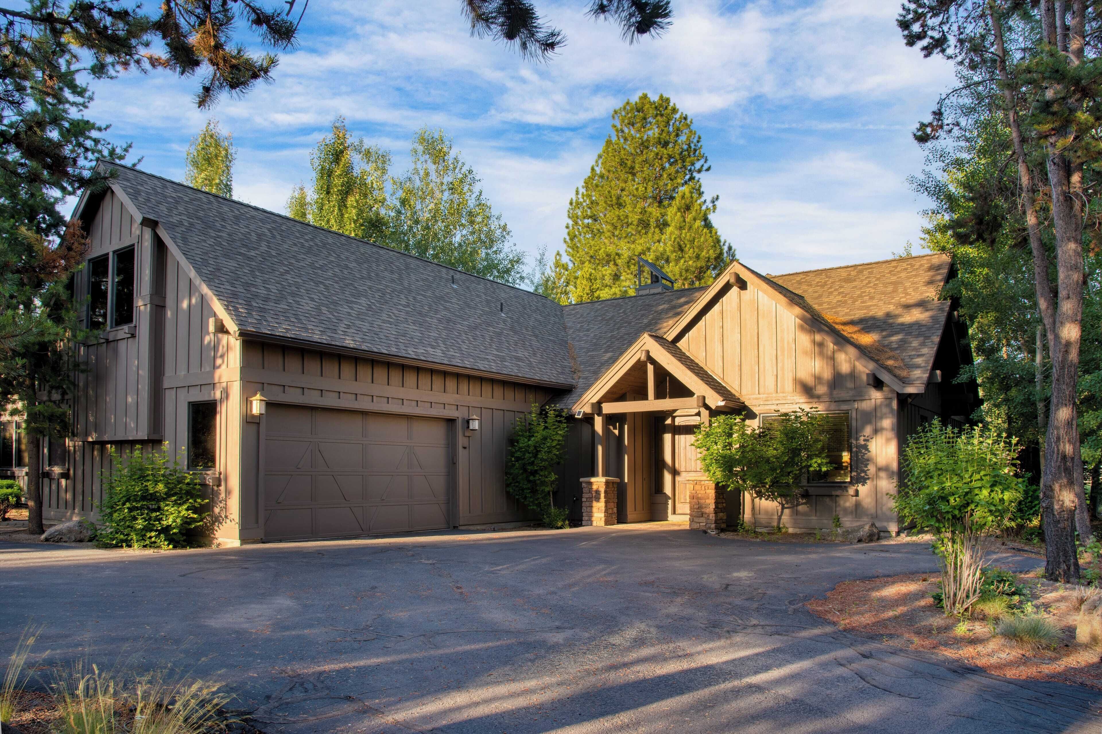 A two-story house with a garage, a covered porch, and a driveway.