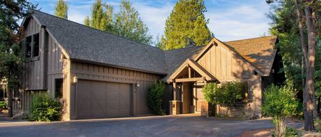 A two-story house with a garage, a covered porch, and a driveway.