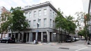 A historic building with a corner entrance, large windows, and a flat roof. - Bright & Sunny CBD FQ Convention Center Area Condo (New Orleans)