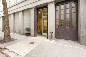 Um edifício com uma porta grande e marrom escura e entrada de vidro.