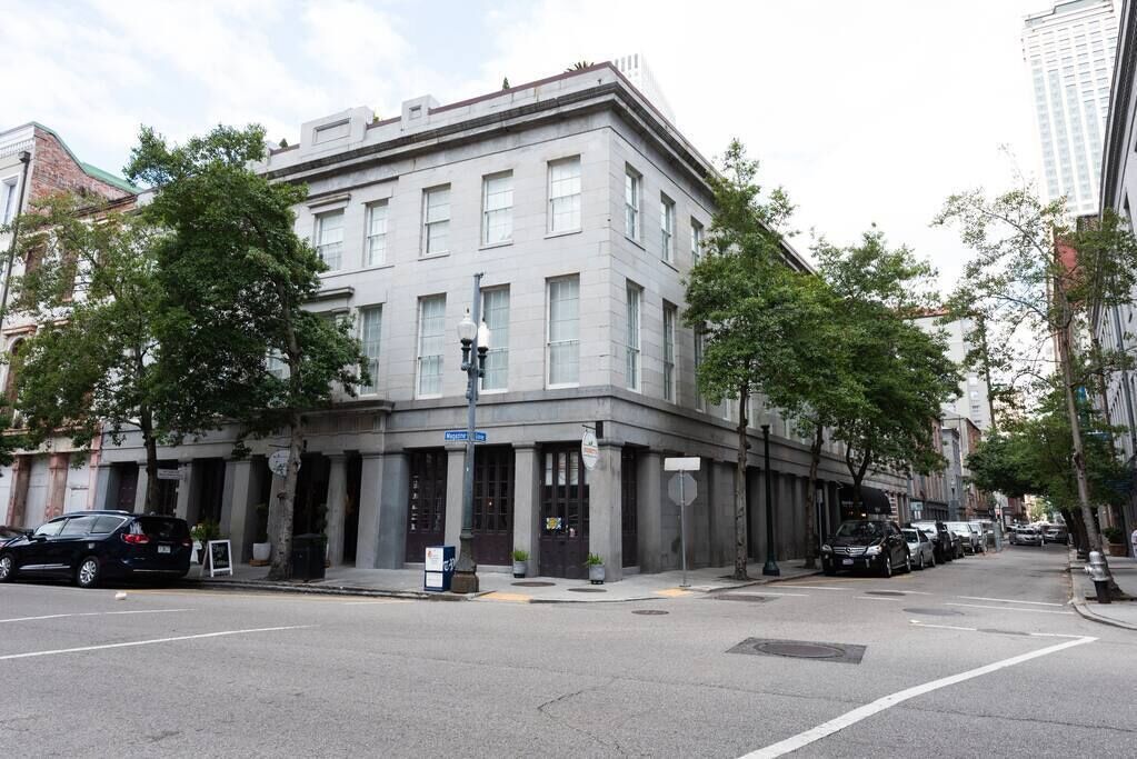 A historic building with a corner entrance, large windows, and a flat roof.