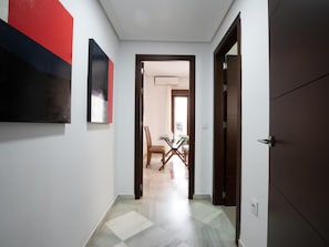 A hallway with a dining area visible through an open door.