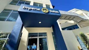 Une enseigne d’hôtel portant le nom « Imperial Suites » et arborant un logo représentant un palmier.