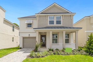 A two-story residential building with a garage, a front porch, and a small garden area. - SpecialOffer-7BR with PrivatePool/GameRoom1859TPC (Four Corners)