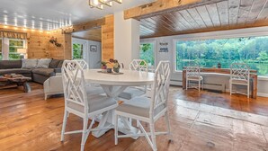 A wooden interior with a dining table, chairs, and a view of the outdoors. - Lakefront, Kayaks, Firepit, great baseball stay! (Maryland)