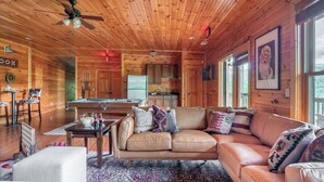 A cozy cabin interior with a wooden ceiling, a dining area, a sofa, and a kitchen. - Hickory Ridge by Avantstay Sleeps 20! Incredible Private Elevated Cabin (Gatlinburg)