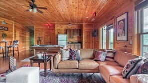 A cozy cabin interior with a wooden ceiling, a dining area, a sofa, and a kitchen. - Hickory Ridge by Avantstay Sleeps 20! Incredible Private Elevated Cabin (Gatlinburg)