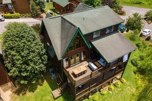 A two-story log cabin with a deck and outdoor seating area. - Tennessee Blue by Avantstayheart of Pigeon Forge! (Pigeon Forge)