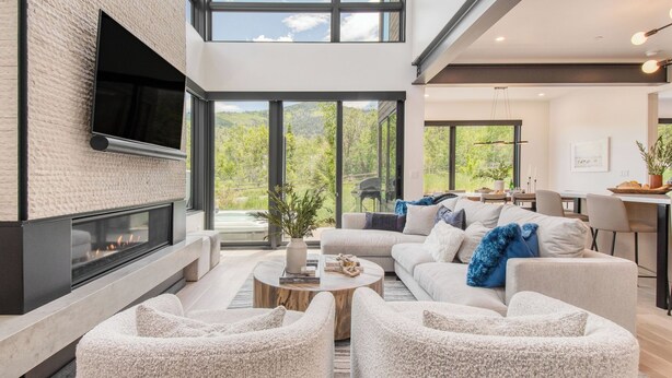 A modern living room with a fireplace, a sofa set, a coffee table, and a dining area with a view of greenery. - Encore by Avantstayminutes From the Slopes in PC! w/ Hot Tub (Park City)