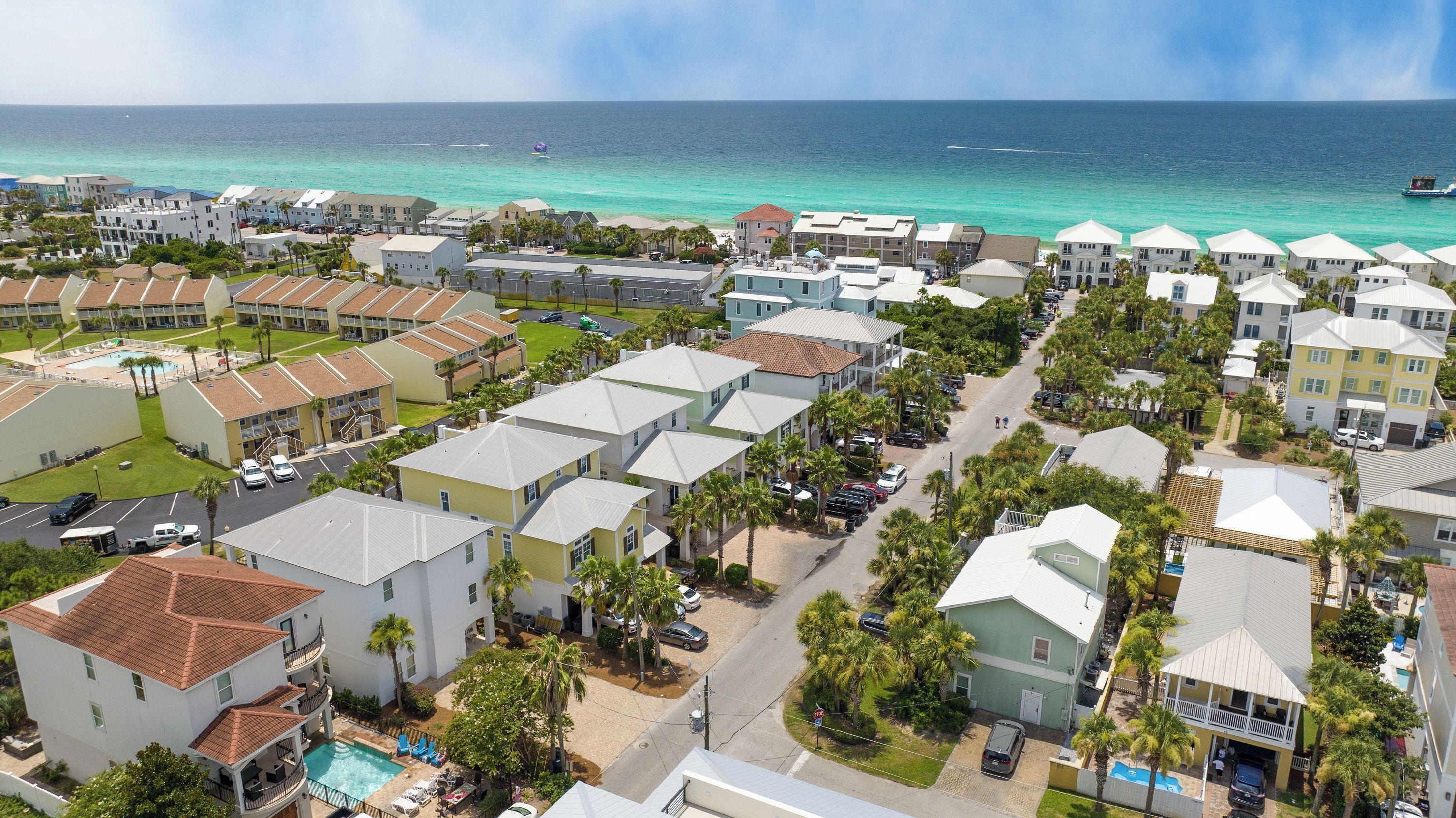 A coastal residential area with multiple-story buildings, a swimming pool, and a view of the ocean.