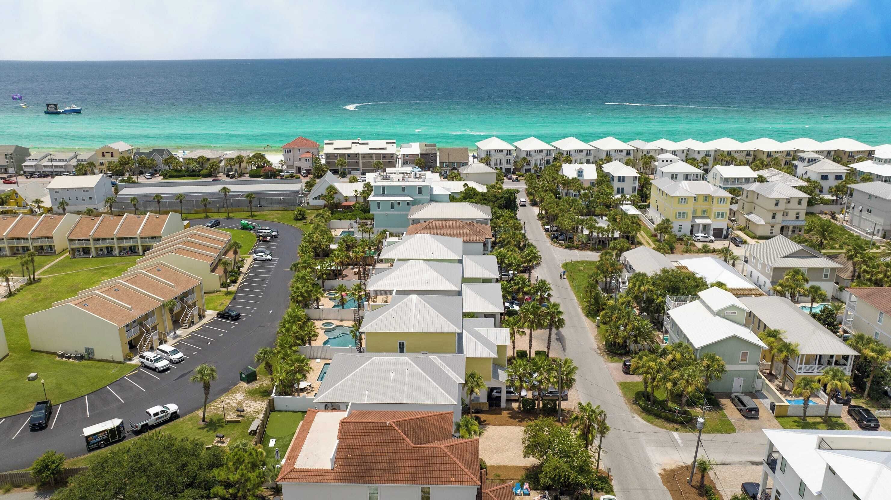 Una zona residencial costera con una hilera de casas, una piscina y vista al océano.