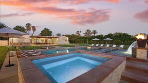Une piscine avec des chaises longues, un patio couvert et une maison en arrière-plan.