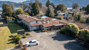 A residential area with houses, a parking lot, and a car. - Te Anau Central Backpackers (Te Anau)