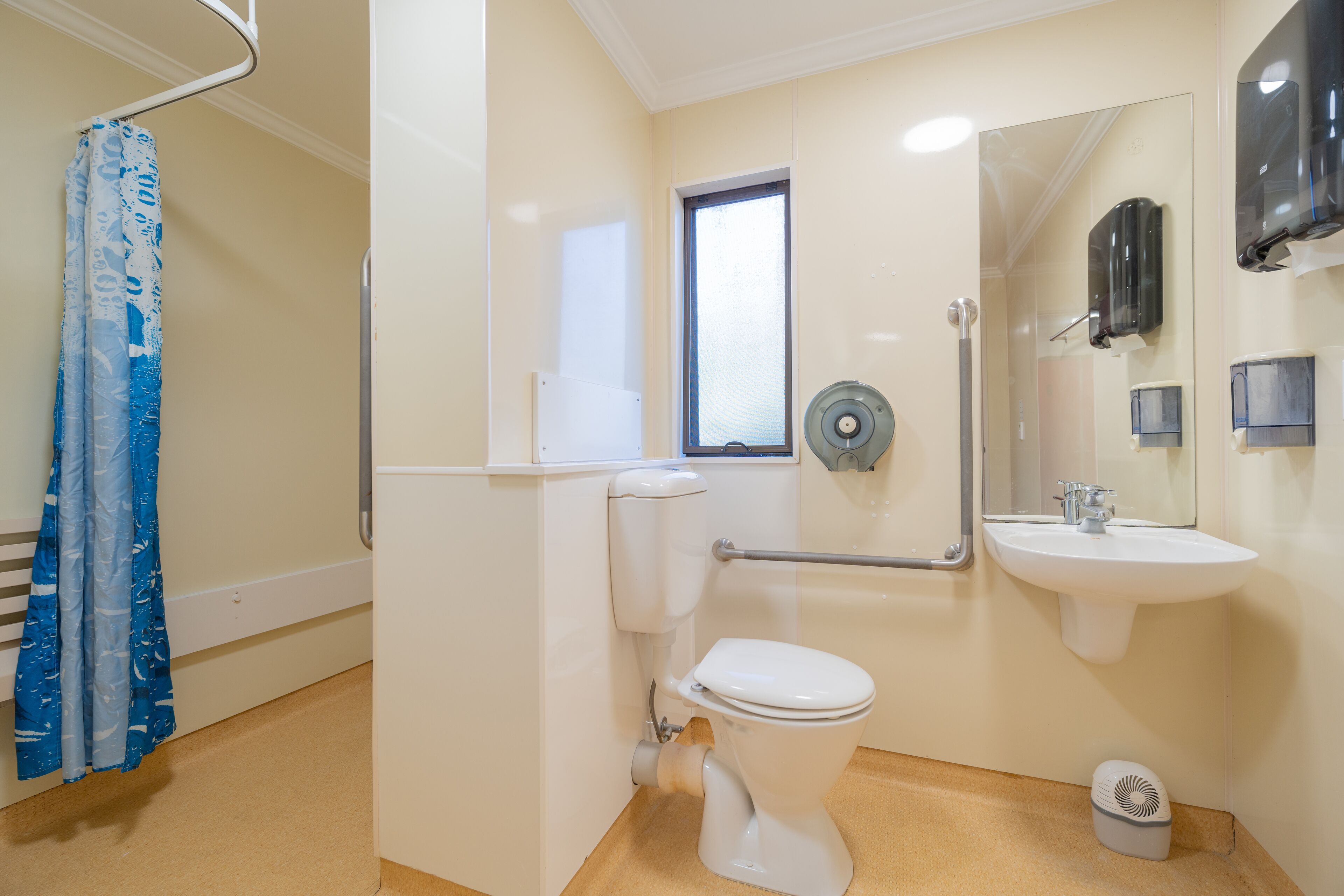 A modern bathroom with a toilet, sink, and shower.