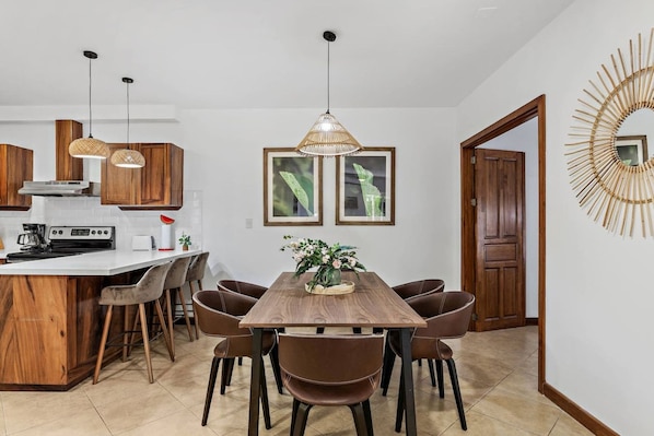 Una cocina moderna con una isla central, armarios de madera e iluminación colgante.