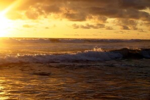 Solnedgang over havet med bølger.