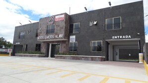 Un edificio con un letrero que dice "HOTEL & MOTEL ALJIBE" y "ENTRADA", indicando la entrada.