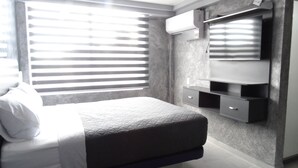 Un dormitorio con cama, cómoda, espejo y ventana con persianas.