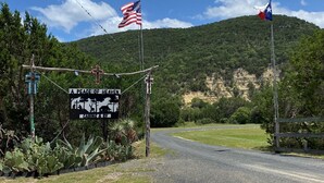A road leading to a mountainous area with a sign indicating a place of worship and cabins. - A Peace of Heaven LOG Cabins & RV- Cabin #1 (Vanderpool)