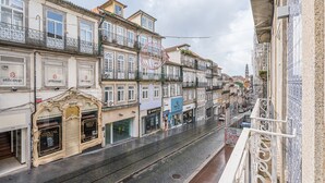 A street view with buildings, a tram, and a sign for 'Stilcoup'. - GuestReady - Modern Apartment in Bolhão (Porto)