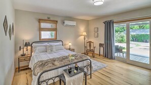 A bedroom with a bed, bedside lamps, a window with blinds, an air conditioner, and a view of the outdoors. - Mountain View Home Steps to Amphitheater Park (Mountain View)