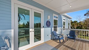 A blue house with a deck, a welcome sign, and two blue chairs. - New!!  The Blue Pelican!  Stunningl canal front beauty with direct gulf access! (Sanibel)