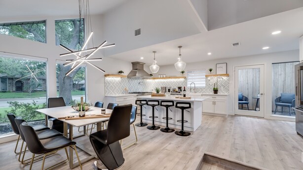 A modern kitchen with a central island, bar stools, and a dining area with a table and chairs. - Lux Dallas Oasis- Pool, Hot Tub, Firepit, Game Room, Sleeps 12 (Dallas)