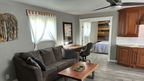 Una sala de estar con sofá, mesa de centro y comedor con mesa y sillas.