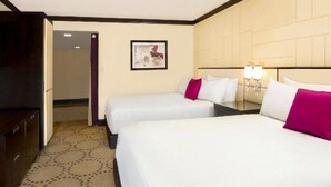 Une chambre d’hôtel avec deux lits, une table de chevet, une commode et un tableau encadré au mur.