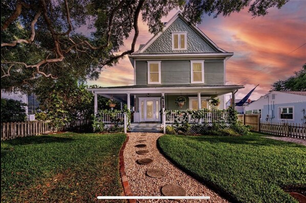 Stunning two-story house with a charming porch and beautifully manicured lawn.