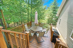 Enjoy a tranquil outdoor space with a round table and comfortable seating under a shaded area.
