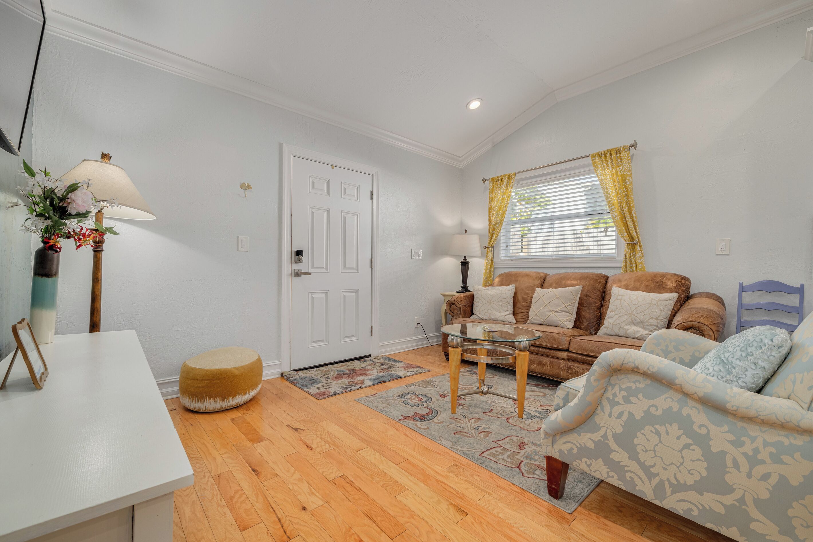 A living room with a white door, a sofa, a coffee table, and a lamp.